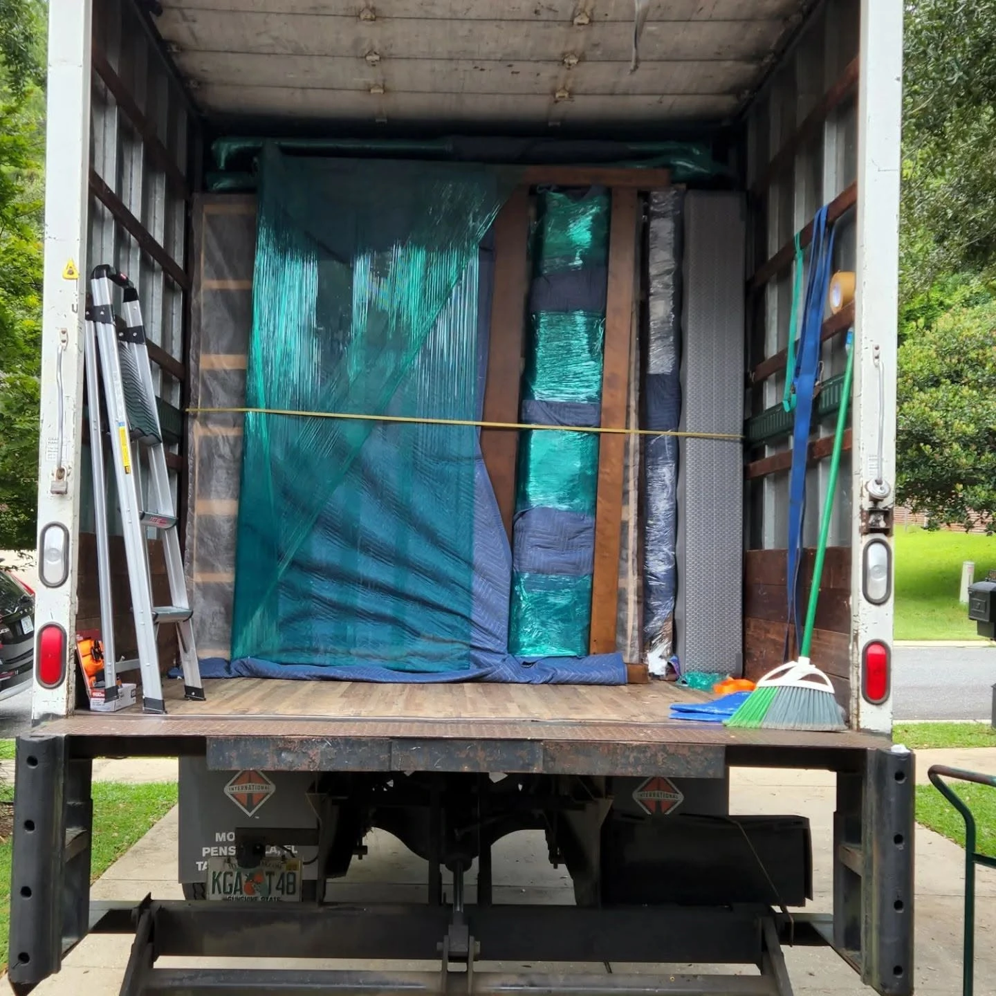 Furniture wrapped in moving blankets and shrink wrap, strapped securely inside a Master Movers of Tallahassee truck